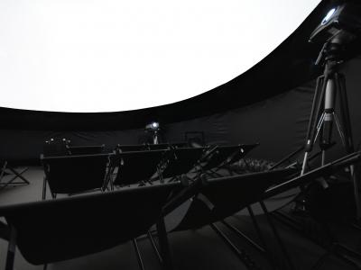Eine Innenaufnahme  des aiRdome | VR  mit Bestuhlung, Projektoren und dem hochwertigen 360° Screen.